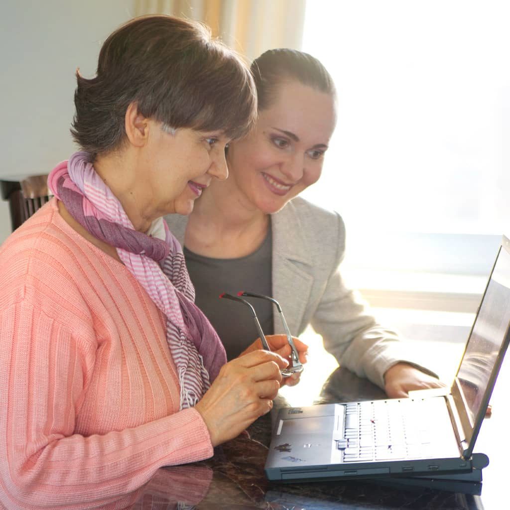 caregiver teaching someone how to use computer